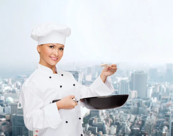 Smiling female chef with pan and spoon — Stock Photo, Image