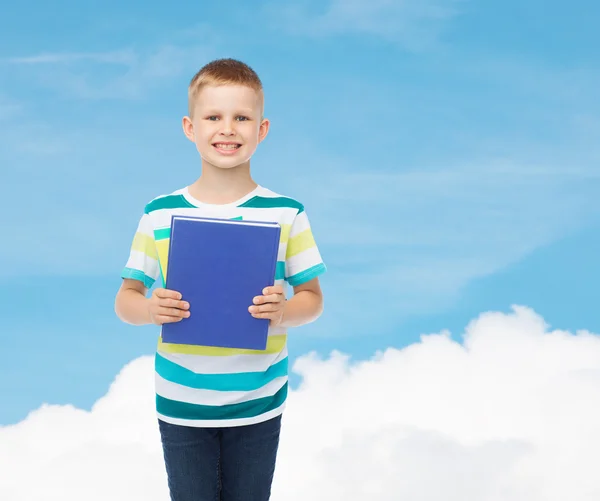 Petit garçon étudiant souriant avec livre bleu — Photo