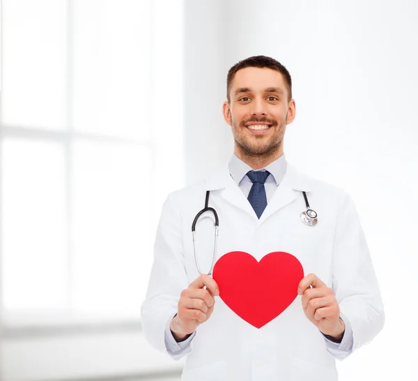 Sonriente médico varón con corazón rojo — Foto de Stock