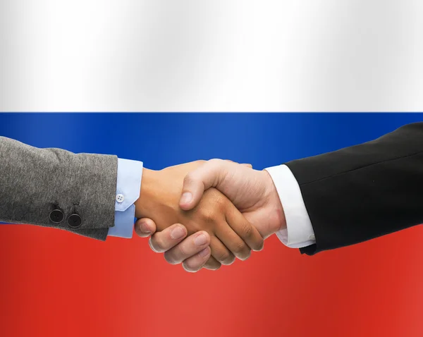 Primer plano del apretón de manos sobre la bandera rusa — Foto de Stock