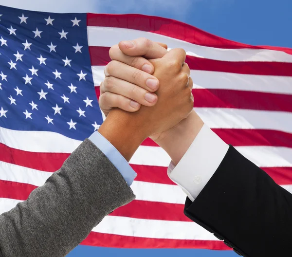 Close up of hands armwrestling over american flag — Stock Photo, Image