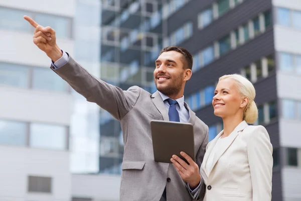 Hombres de negocios sonrientes con tableta pc al aire libre — Foto de Stock