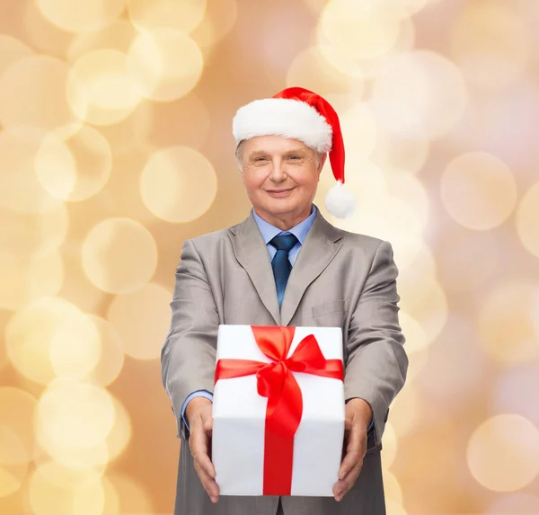 Smiling man in suit and santa helper hat with gift — Stock Photo, Image