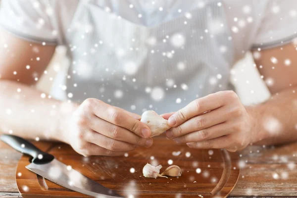 Close up of male hands taking off garlic peel — 图库照片