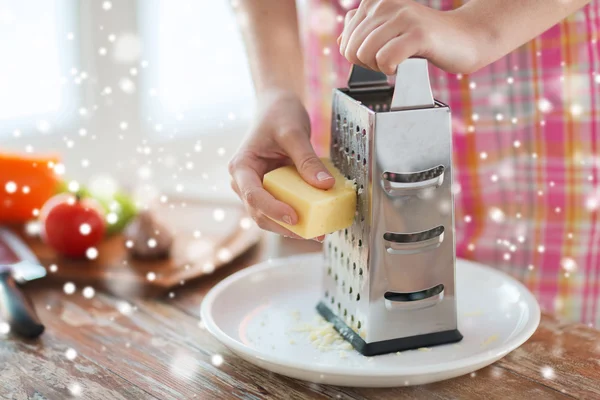 Close up of woman hands with grater grating cheese — Stock Photo, Image