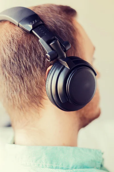 Close up de homem em fones de ouvido em casa — Fotografia de Stock