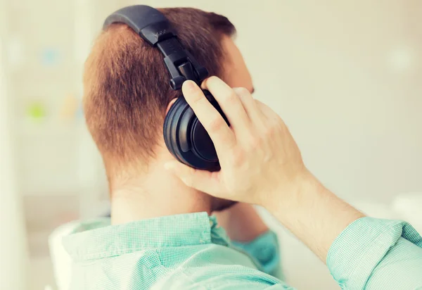 Close up de homem em fones de ouvido em casa — Fotografia de Stock