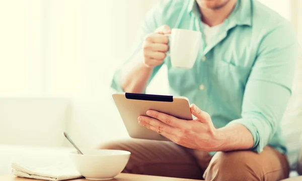 Close up of man with tablet pc having breakfast — Stock Photo, Image