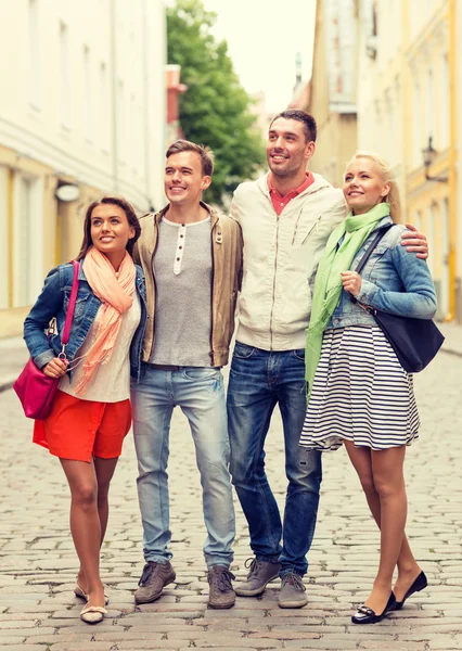 Gruppo di amici sorridenti che passeggiano in città — Foto Stock