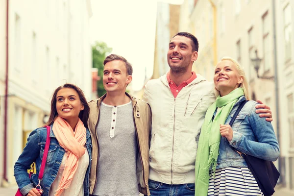 Groep lachende vrienden wandelen in de stad — Stockfoto