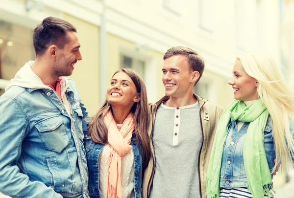 Groep lachende vrienden wandelen in de stad — Stockfoto