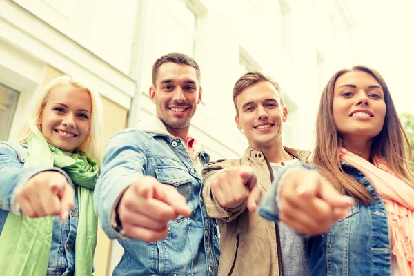 Grupp leende vänner i staden pekande finger — Stockfoto