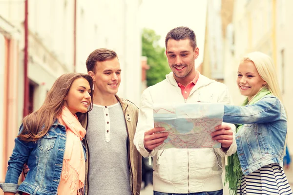 Grupo de amigos sorridentes com mapa explorando a cidade — Fotografia de Stock