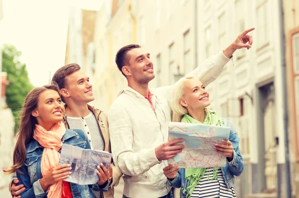 Groupe d'amis souriants avec guide de la ville et la carte — Photo