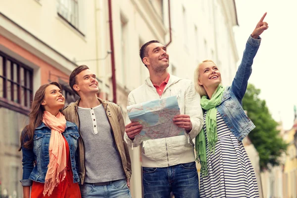 Grupp leende vänner med karta att utforska staden — Stockfoto