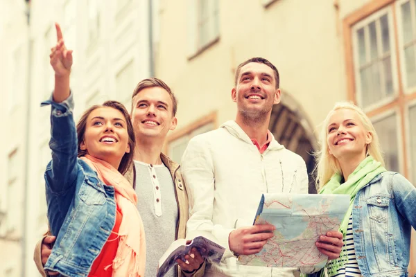 Group of smiling friends with city guide and map — Stock Photo, Image