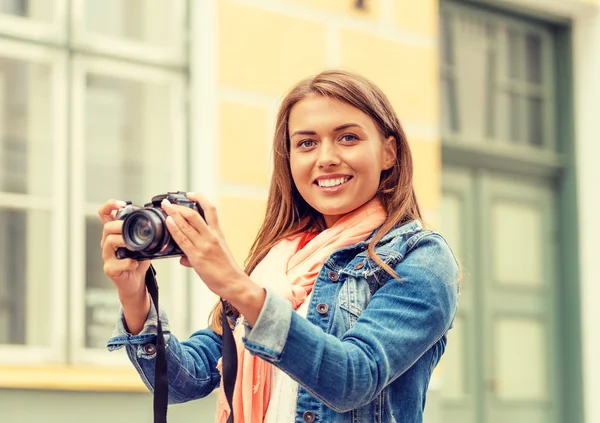 Usměvavá dívka s digiral fotokamery ve městě — Stock fotografie