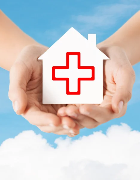 Hands holding paper house with red cross — Stock Photo, Image