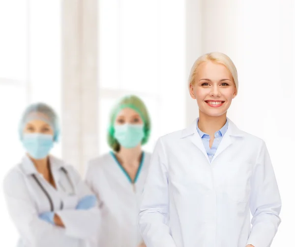 Smiling female doctor with group of medics — Stock Photo, Image