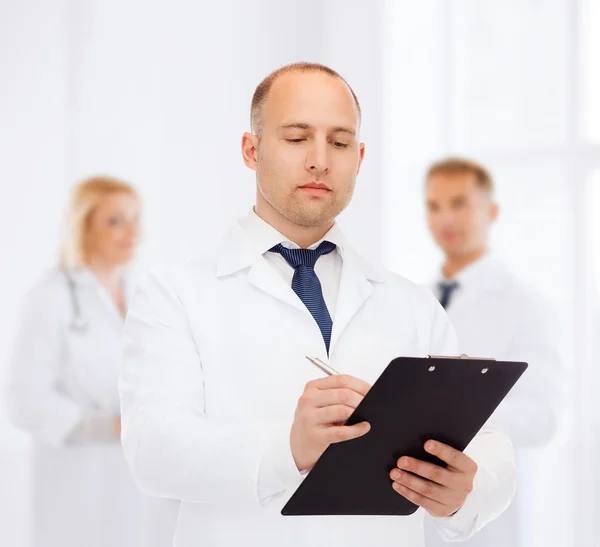 Serious male doctor with clipboard — Stock Photo, Image