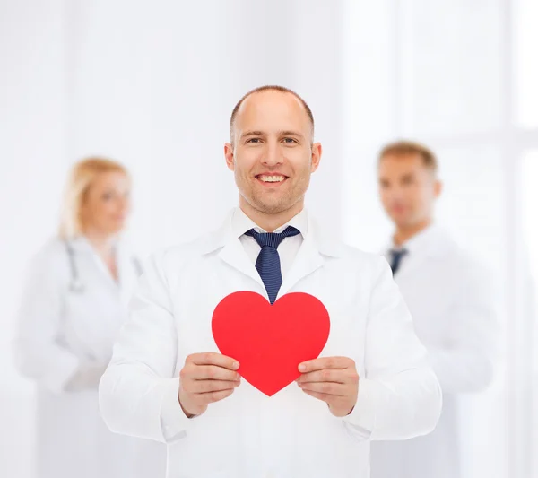 Médecin masculin souriant avec coeur rouge — Photo
