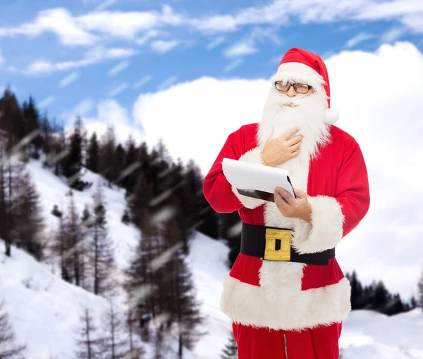 Homme en costume de Père Noël claus avec bloc-notes — Photo