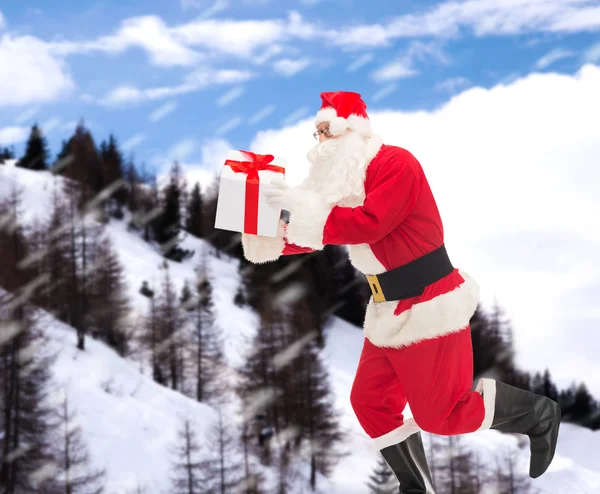 Homem em traje de santa claus com caixa de presente — Fotografia de Stock