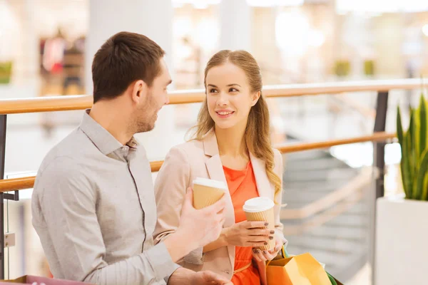 Coppia felice con borse della spesa bere caffè — Foto Stock