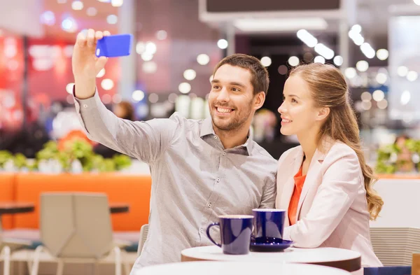Gelukkige paar met smartphone nemen selfie in winkelcentrum — Stockfoto