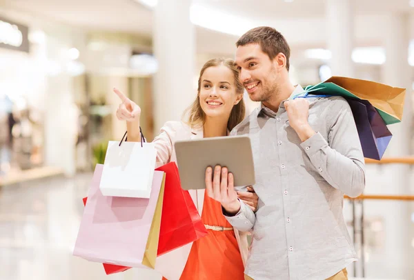 Par med TabletPC och påsar i gallerian — Stockfoto