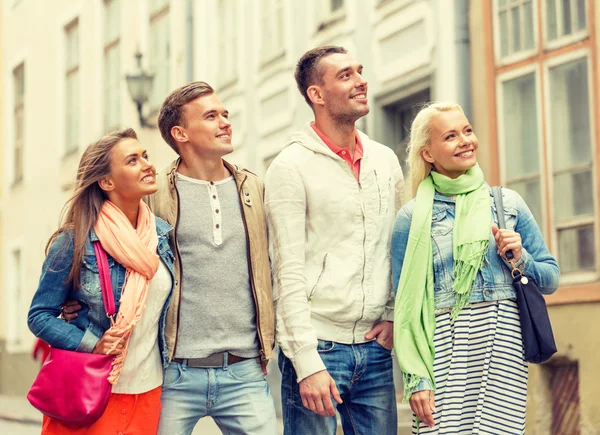 Gruppo di amici sorridenti che passeggiano in città — Foto Stock