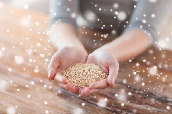 Close up de fêmea copa mãos com quinoa — Fotografia de Stock