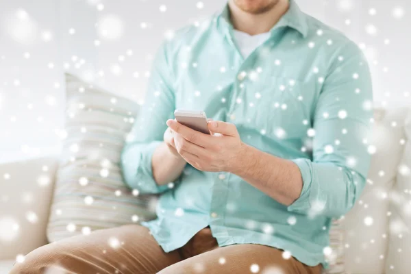 Nahaufnahme eines Mannes, der mit Smartphone zu Hause sitzt — Stockfoto