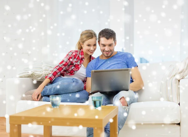 Smiling couple with laptop computer at home — Stock Photo, Image