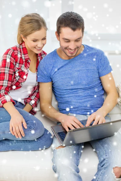 Pareja sonriente con ordenador portátil en casa —  Fotos de Stock