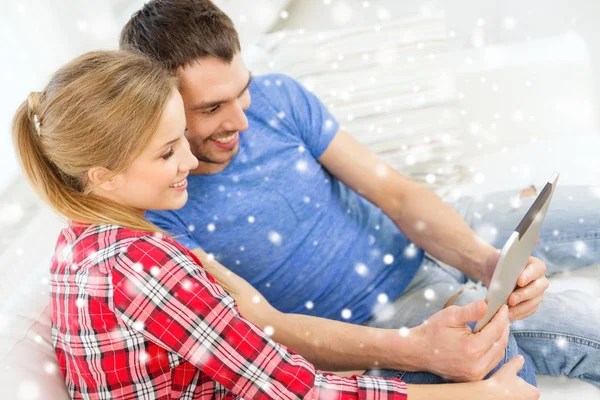 Usmívající se pár s počítačem tablet pc doma — Stock fotografie