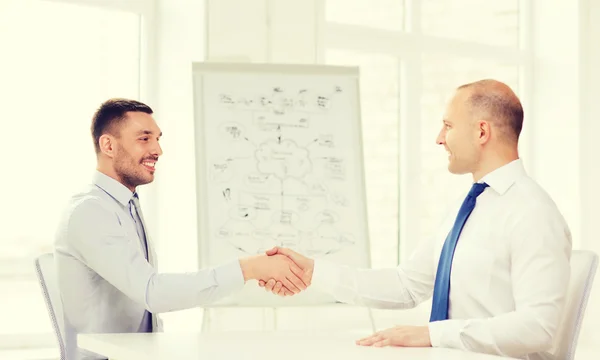 Due uomini d'affari sorridenti che si stringono la mano in ufficio — Foto Stock