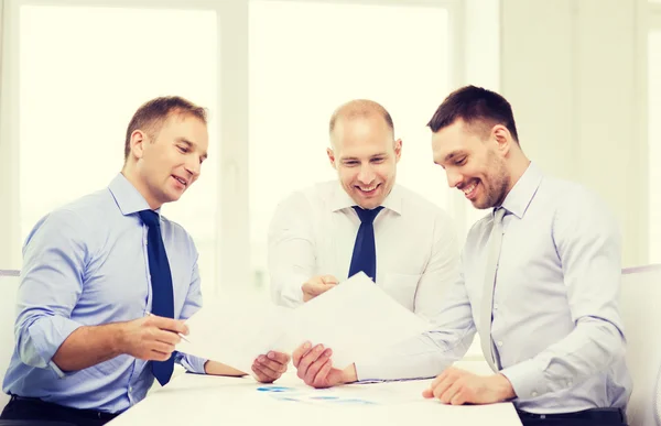 Smiling businessmen with papers in office — Stock Photo, Image
