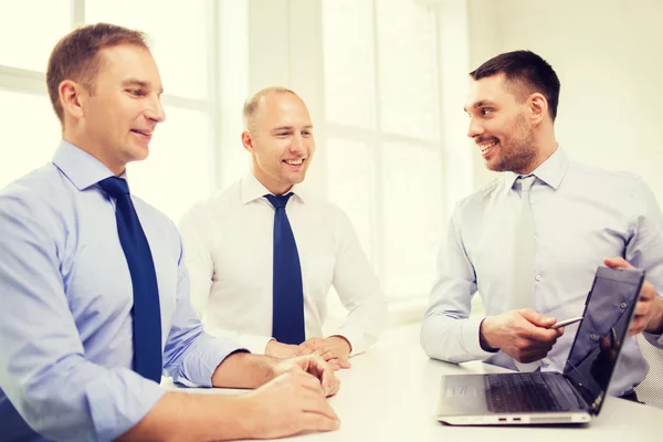 Des hommes d'affaires souriants discutant au bureau — Photo