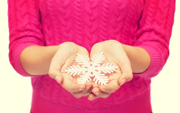 Close up of woman in sweater holding snowflake — Stock Photo, Image