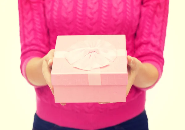Close up de mulher em suéter rosa segurando caixa de presente — Fotografia de Stock