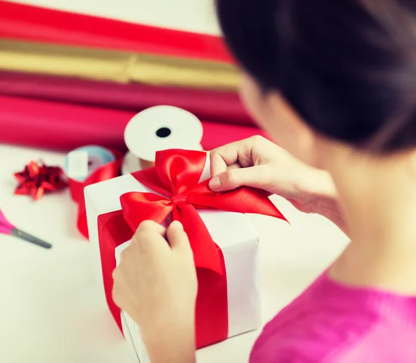 Nahaufnahme einer Frau, die Weihnachtsgeschenke dekoriert — Stockfoto
