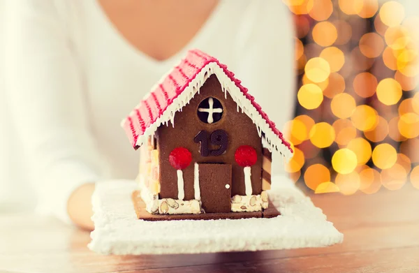 Kadın gösteren gingerbread evi yakın çekim — Stok fotoğraf