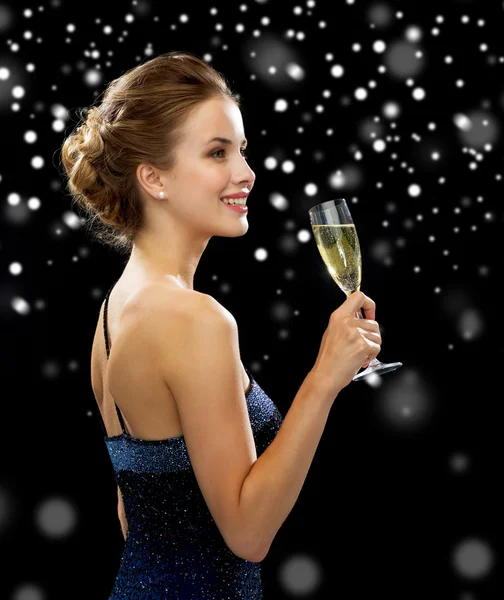 Sonriente mujer sosteniendo un vaso de vino espumoso — Foto de Stock