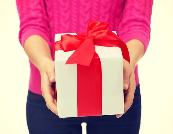 Close up of woman in pink sweater holding gift box Stock Picture