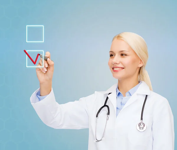 Female doctor drawing mark to check box — Stock Photo, Image