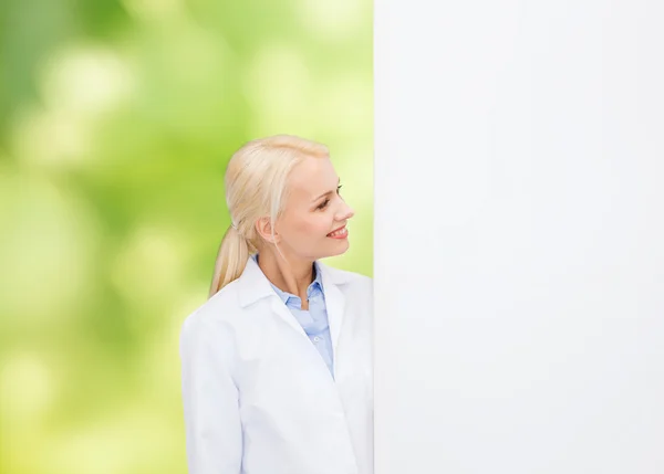 Médica sorridente com placa branca em branco — Fotografia de Stock