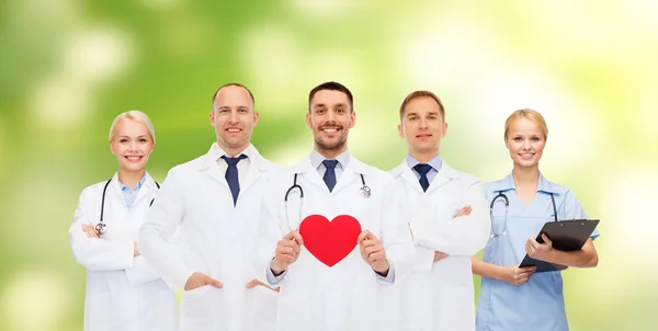 Ομάδα χαμογελαστό γιατρών με κόκκινη καρδιά σχήμα — Φωτογραφία Αρχείου