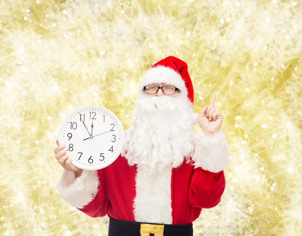 Man in costume of santa claus with clock — Stock Photo, Image