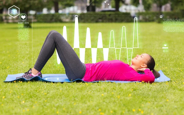 Mulher sorrindo fazendo exercícios no tapete ao ar livre — Fotografia de Stock
